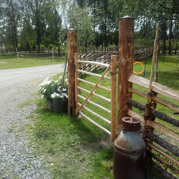 Enkel pinngrind i trä med Roslagsgärdsgård som staket. 